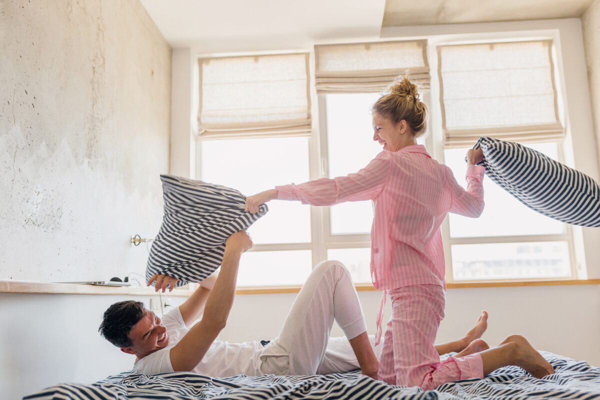 young couple having fun on bed in morning